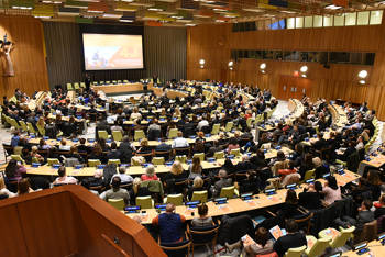 A large room filled with people watch a screening of the documentary 4.1 miles, in the United Nations